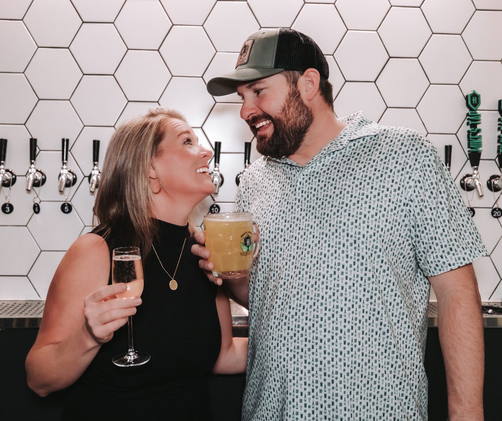 Adam and Allie, owners of Hopsology, sharing a laugh at the tap wall